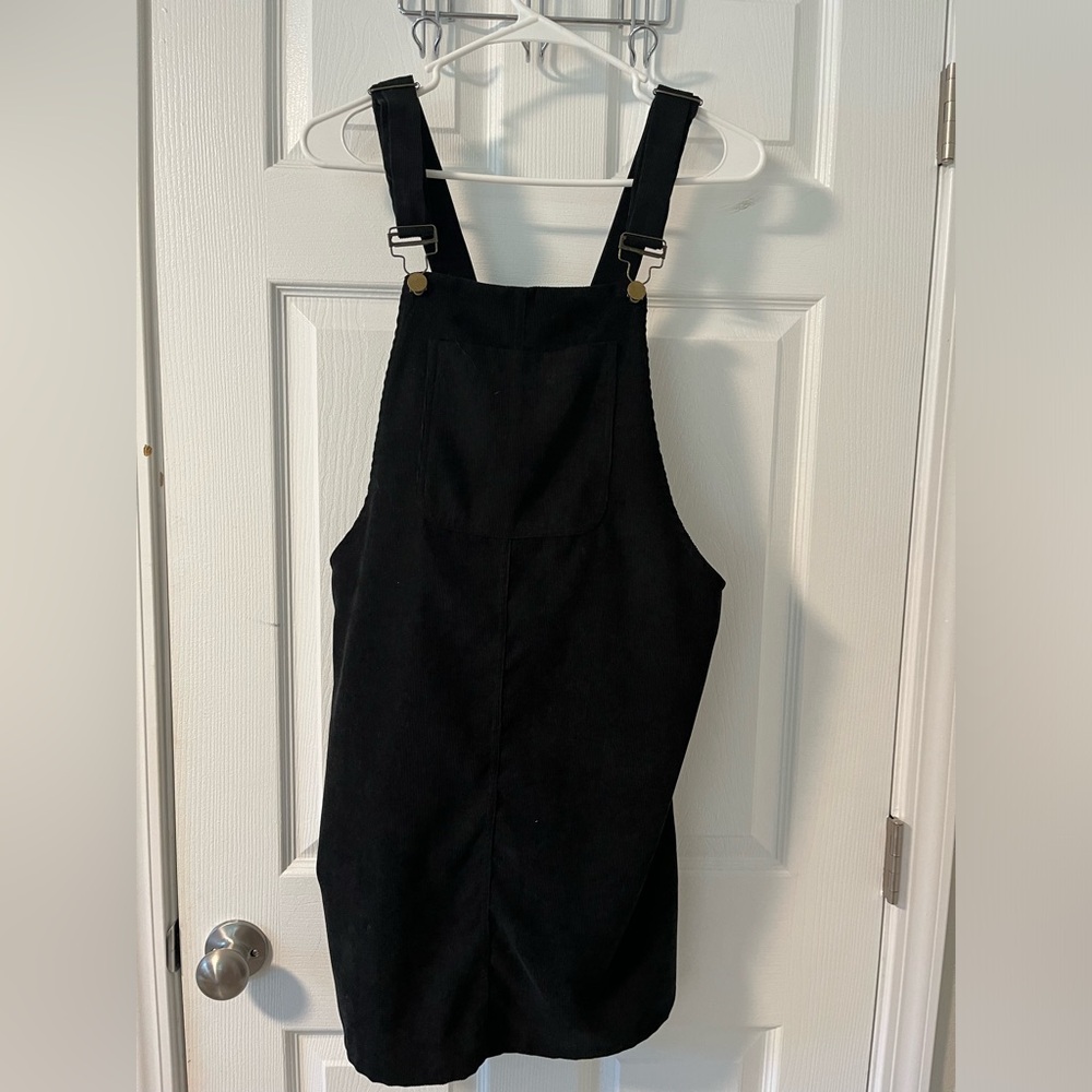 Black, A-line dress. Two back pockets, top straps buckle to front buttons!